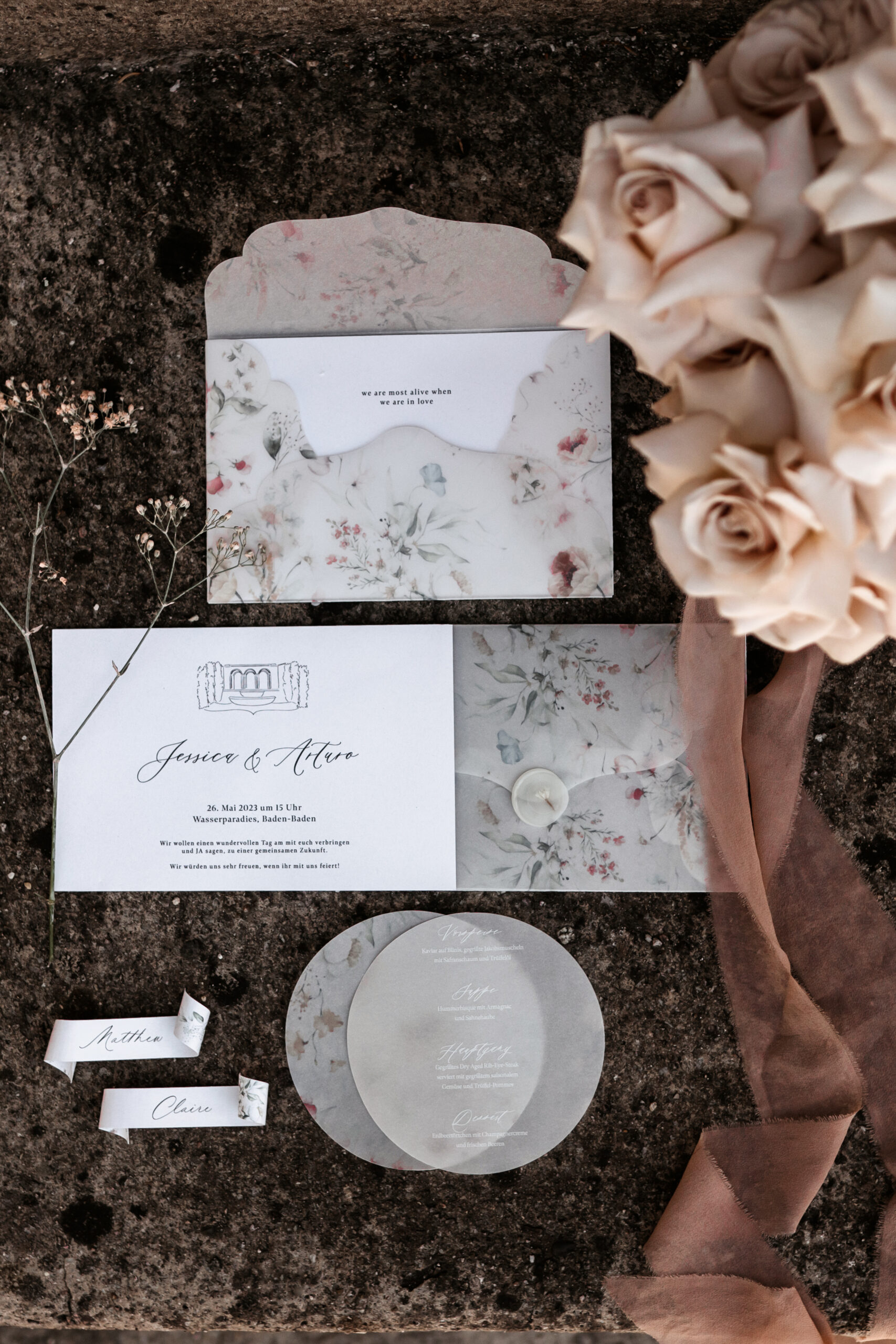 Florale Hochzeitseinladung und Menükarte neben einem Strauß heller Rosen – Hochzeitsfotografie von Kenan Egin