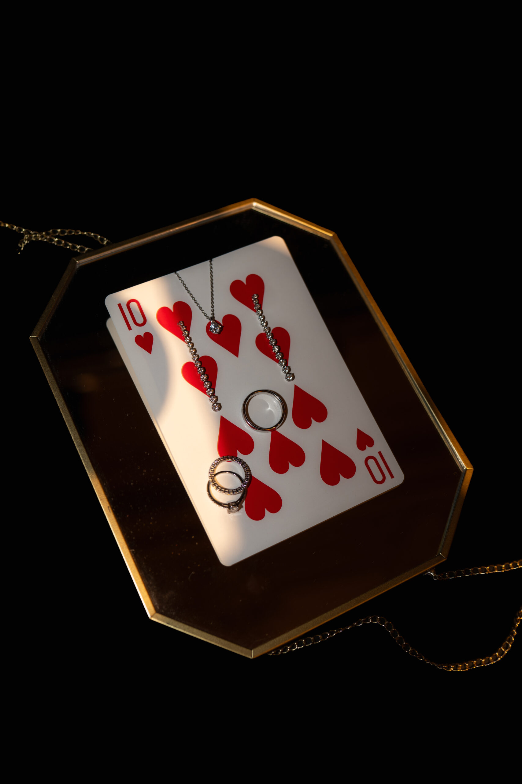 Ringe, Ohrringe und eine Halskette auf einer Herz-Zehn-Spielkarte in einer goldgerahmten Schale beim Editorial Shooting im Grand Casino Luzern.